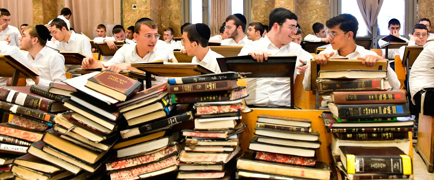 Stacks of well-worn seforim piled on the beis medrash tables