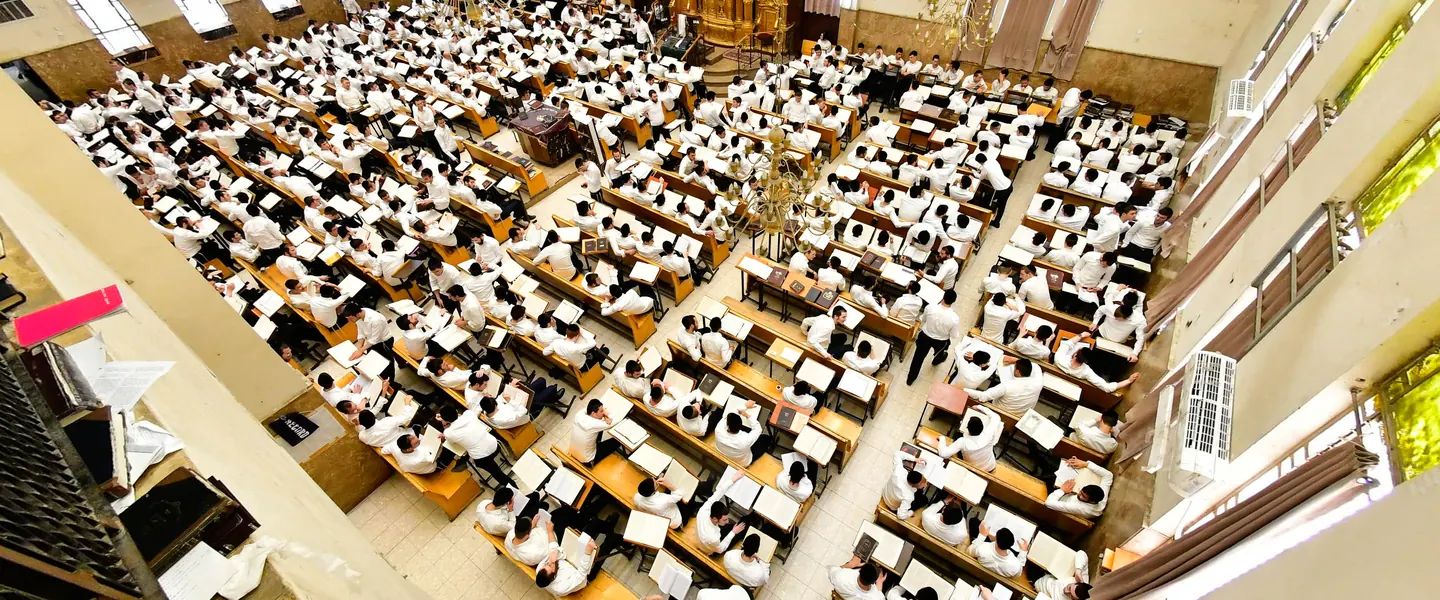The full beis medrash seen from above, every shtender occupied