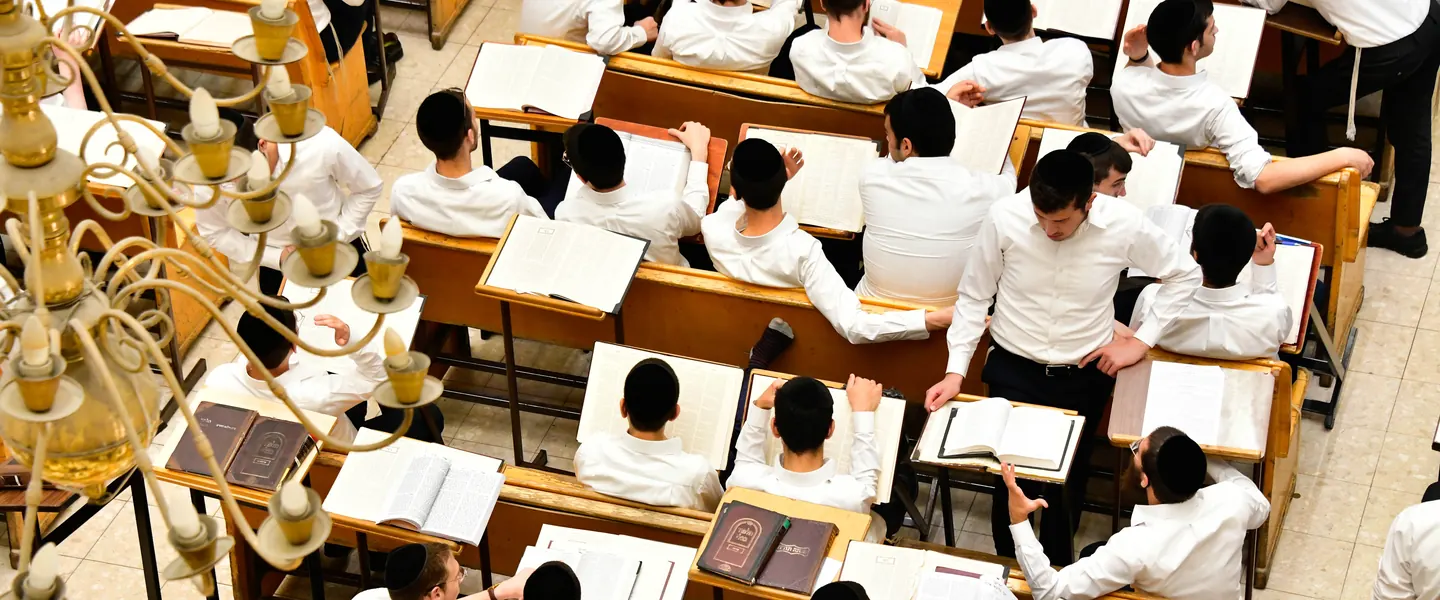 Rows of talmidim over open gemaras seen from above