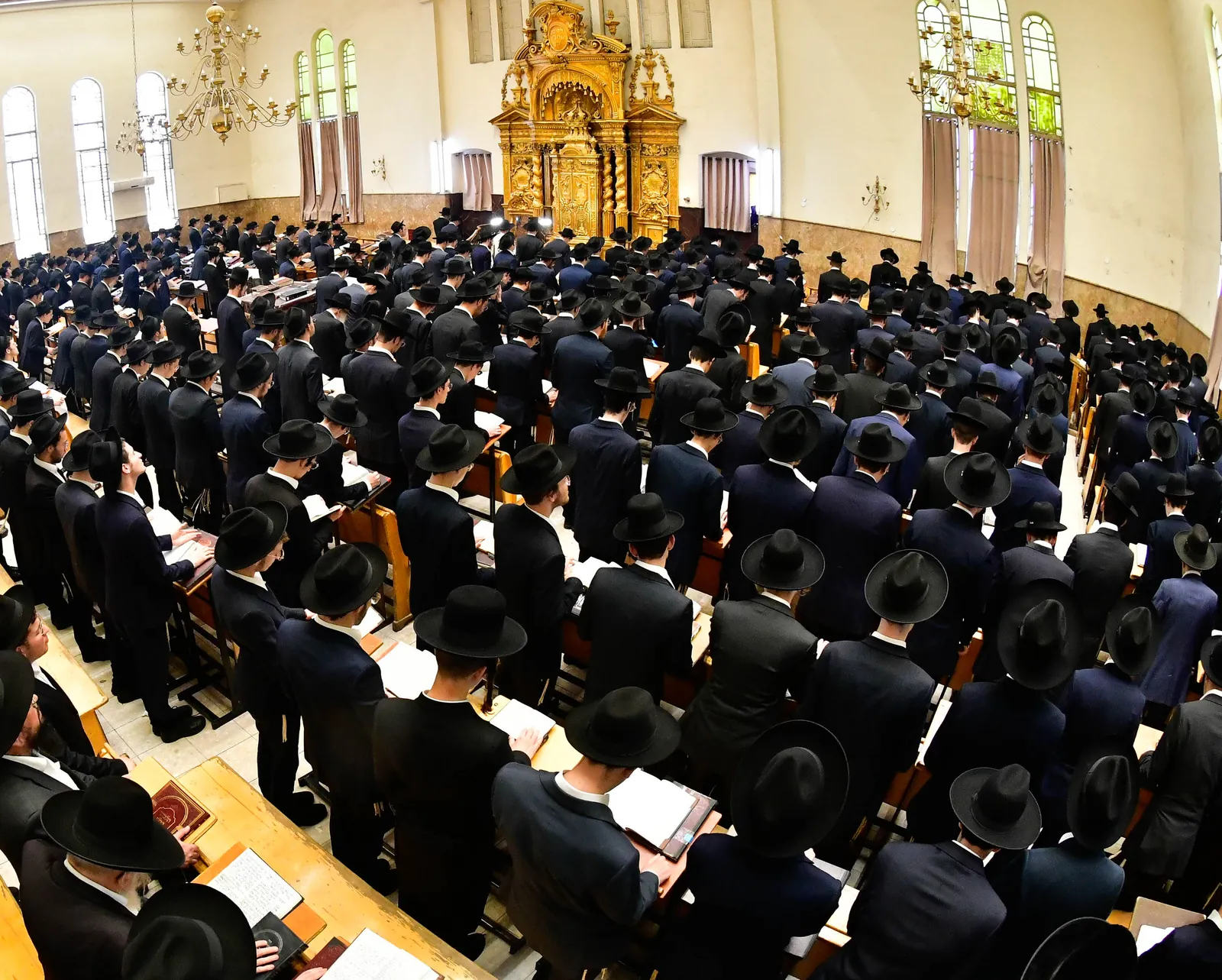 The Ponevez beis medrash standing in tefillah before the aron kodesh