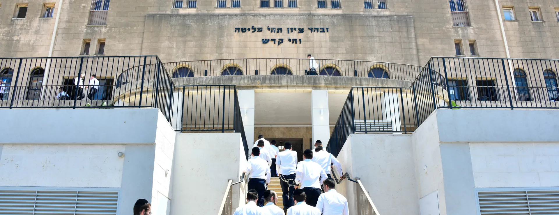Talmidim climbing the front steps of Ponevez Yeshiva in Bnei Brak